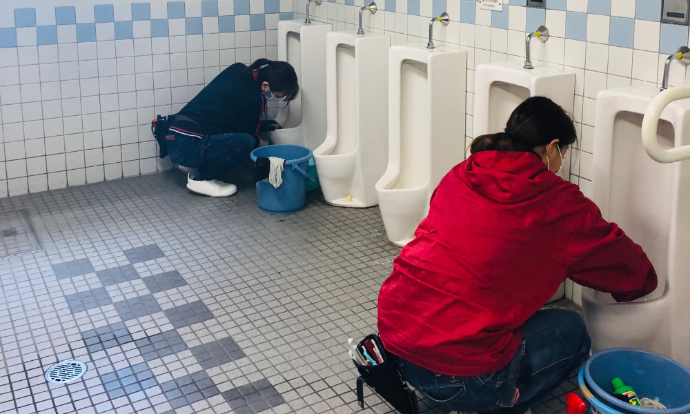 学校のトイレで清掃作業を行うプロのスタッフ